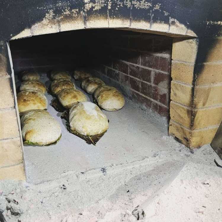 Раскладывание теста на деревянные дощечки для выпечки хлеба в каменной печи